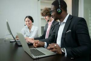 groupe de affaires gens portant casque travail activement dans bureau. appel centre, télémarketing, client soutien agent fournir un service sur Téléphone vidéo conférence appel. photo