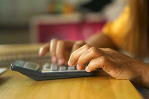 asiatique femmes presse à travail de Accueil Cliquez sur sur le calculatrice à voir bénéfices. photo