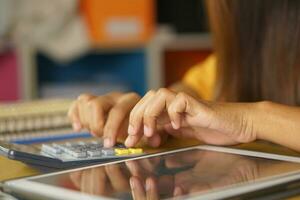 asiatique femmes presse à travail de Accueil Cliquez sur sur le calculatrice à voir bénéfices. photo