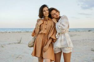 été mode image de deux brunette européen femmes dans lin vêtements posant sur le plage photo