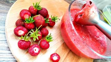 mixeur dans un plat en verre avec purée de fraises photo