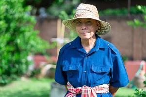 portrait d'un fermier asiatique senior avec un visage souriant debout dans une ferme photo