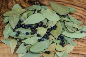 feuilles de laurier et baies de genièvre sur bois d'olivier