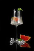 cocktail au pamplemousse sur fond sombre avec un brin de menthe photo