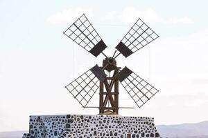 une Moulin à vent sur Haut de une colline avec montagnes dans le Contexte photo