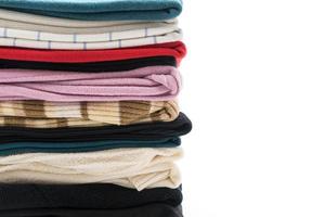 des piles de vêtements sur fond blanc photo