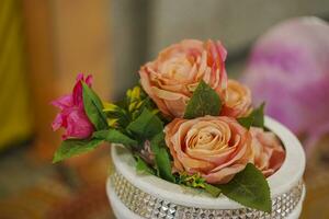 bouquet de plusieurs rose des roses avec feuille dans blanc vase photo