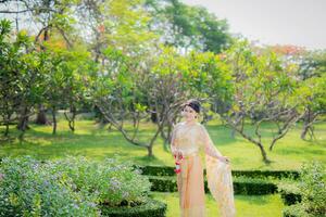 traditionnel thaïlandais costume magnifique femme marcher dans jardin photo