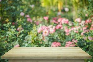 vide bois table Haut avec brouiller Rose jardin Contexte pour produit afficher photo