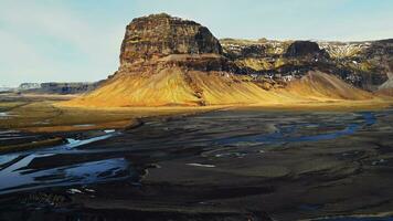 drone coup de énorme Montagne chaîne sur islandais paysage, spectaculaire nordique la nature sur bord de la route. massif collines et neigeux terrains dans Islande, scandinave paysage scénique itinéraire. lent mouvement. photo