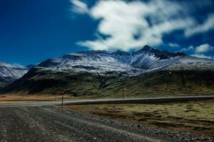 majestueux Région avec montagnes couvert dans neige, nuit la photographie thème. magnifique Autoroute paysage avec glacé pics et glacial pistes dans islandais verdure, spectaculaire horizon voir. photo