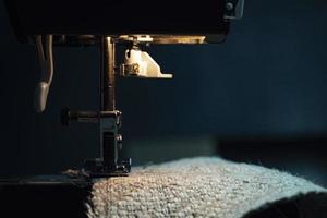 une machine à coudre coud du tissu de jute. coudre des vêtements en tissu de chanvre photo
