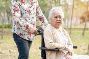 patiente asiatique âgée en fauteuil roulant dans le parc. photo