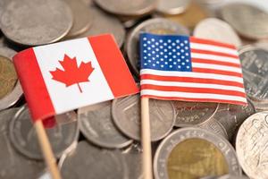 pile de pièces de monnaie avec le drapeau américain et canadien, concept financier. photo