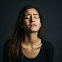 femme apparaît à être dans douleur sur gris Contexte ai génératif photo