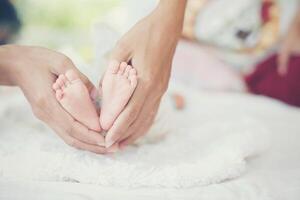 pieds de bébé nouveau-né dans les mains de la mère. photo