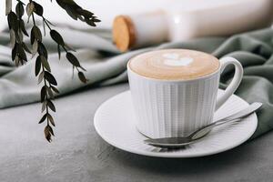 proche en haut de tasse de café avec cœur fleur peint sur mousse photo