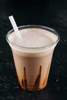 Milk-shake dans une Plastique tasse sur noir Contexte photo