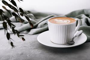 proche en haut de tasse de café avec cœur fleur peint sur mousse photo