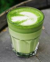 matcha latté vert Lait mousse tasse sur bois baril photo