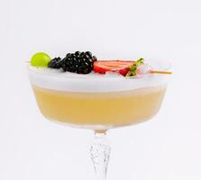 proche en haut Jaune cocktail avec blanc mousse avec baies photo