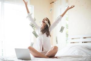 femme avec un billet de banque en dollars sur le lit