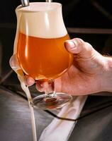 barman verser Frais Bière dans verre dans pub photo