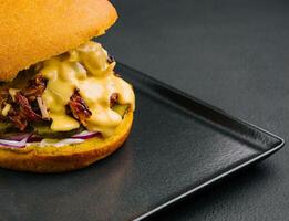 délicieux Burger avec déchiré Viande sur noir plateau photo