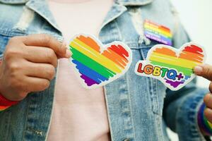 femme asiatique avec drapeau arc-en-ciel, droits des symboles lgbt et égalité des sexes, mois de la fierté lgbt en juin. photo