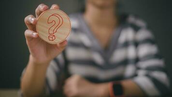 femmes en portant des questions marque sur le en bois bloc. FAQ la fréquence a demandé des questions, répondre, q et un, information, la communication et interrogatoire concepts photo