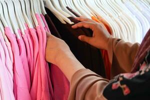 femme choisir vêtements dans magasin. photo