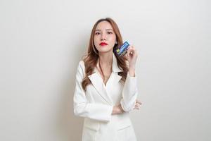 Portrait belle femme asiatique tenant une carte de crédit sur fond blanc photo