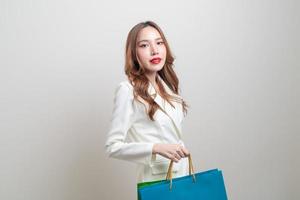 Portrait belle femme asiatique tenant un sac à provisions sur fond blanc photo