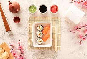 ensemble de sushis dans une boîte en papier kraft jetable avec de la sauce de soja, gingembre photo