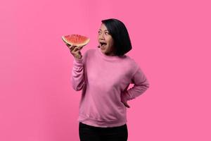 jolie jeune femme asiatique tenant des morceaux de pastèque photo