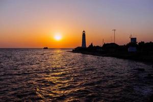 phare sur la côte de la mer au coucher du soleil photo
