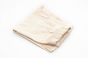 Pli de pantalon beige isolé sur fond blanc photo