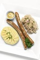 saucisse de thuringe allemande avec purée de pommes de terre et repas de choucroute sur plaque blanche
