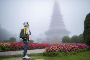 jeune garçon voyageur avec sac dans un beau jardin de brouillard photo