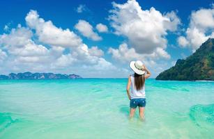 la femme heureuse de voyageur apprécie dans la plage tropicale photo