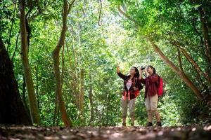 Deux jeunes femmes asiatiques hipster randonnées en forêt photo