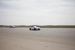 voitures sur la piste de course et sur les routes du désert