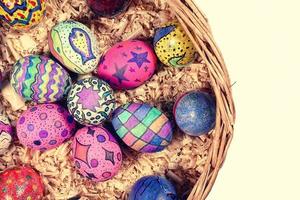 oeufs de pâques colorés dans un panier en bois photo