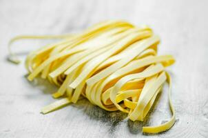 fait maison Pâtes tagliatelles. sur blanc tableau. photo