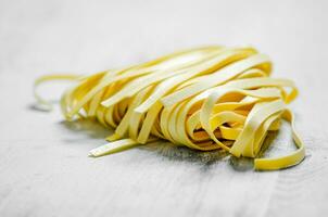 fait maison Pâtes tagliatelles. sur blanc tableau. photo