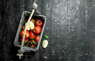 rouge pommes avec feuilles et Pomme tranches dans une en bois boîte. photo