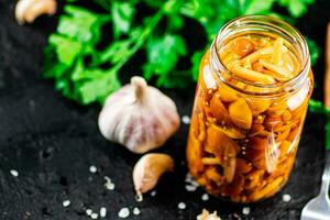 mariné champignons avec une verre pot avec persil et Ail. photo