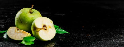 pièces et une entier Pomme avec feuilles sur le tableau. photo