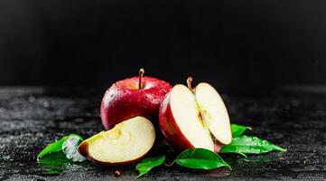 moitié et entier pommes avec feuilles sur le tableau. photo