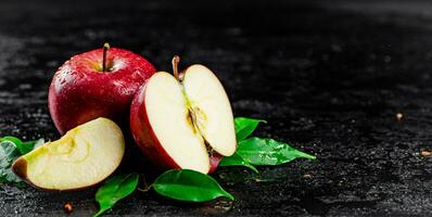 moitié et entier pommes avec feuilles sur le tableau. photo